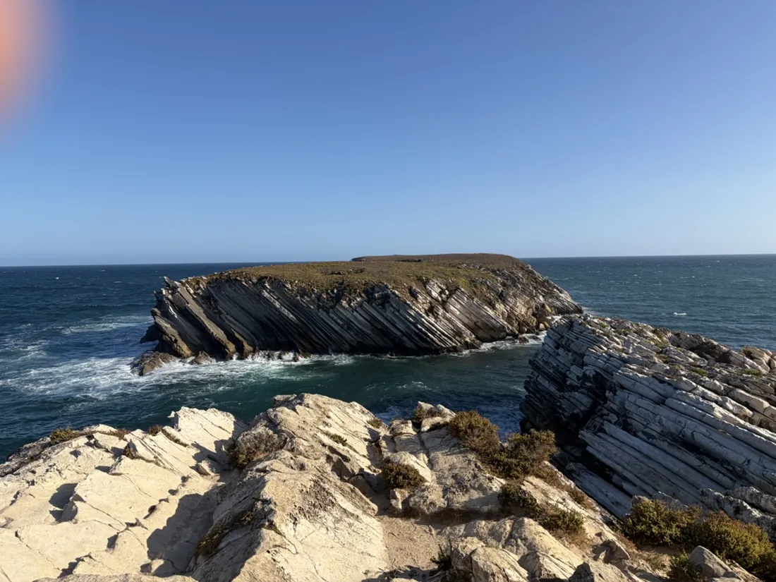 Steil gestellte Jurakalk-Bänke an der Spitze der Insel Baleal, dahinter der Ilhéu de Fora