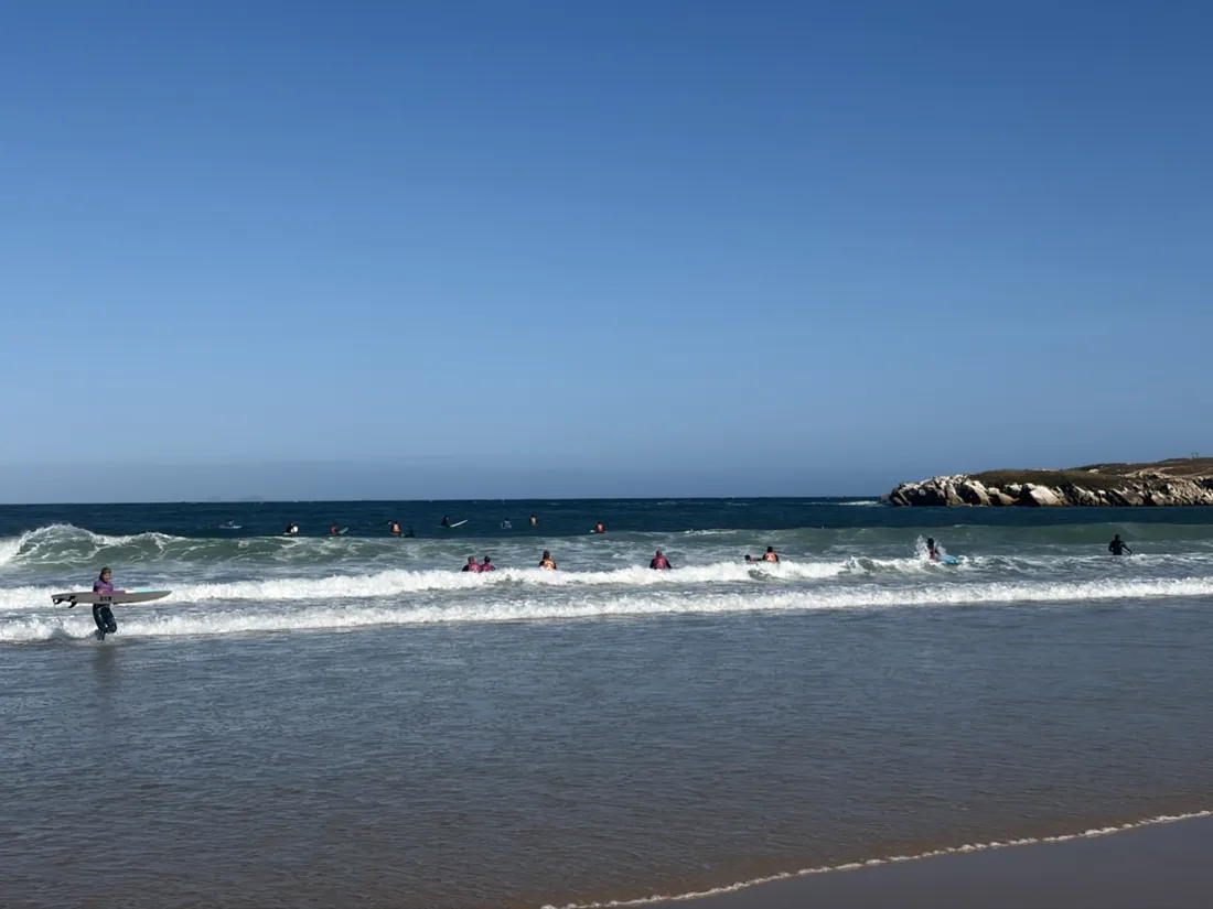 Eine Surfschule im Weißwasser am Nordstrand, die Inselspitze schließt die Bucht