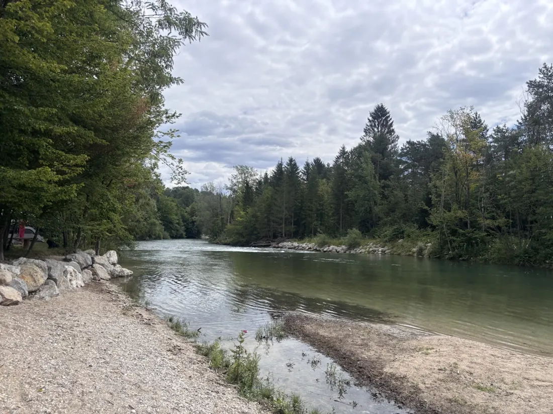 A pebble beach and boulder-lined bank on the Sava Dolinka near Camping Šobec