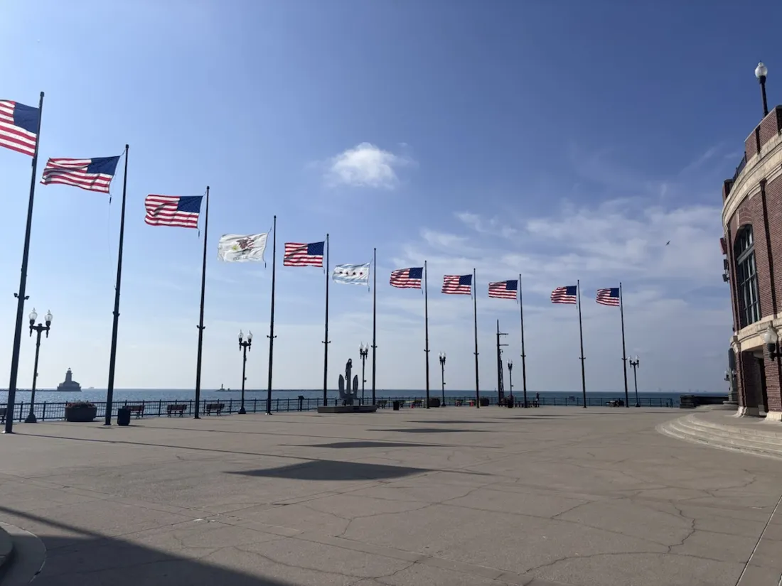 The flag-lined promenade at the end of Navy Pier, with the Chicago Harbor Lighthouse out on the lake