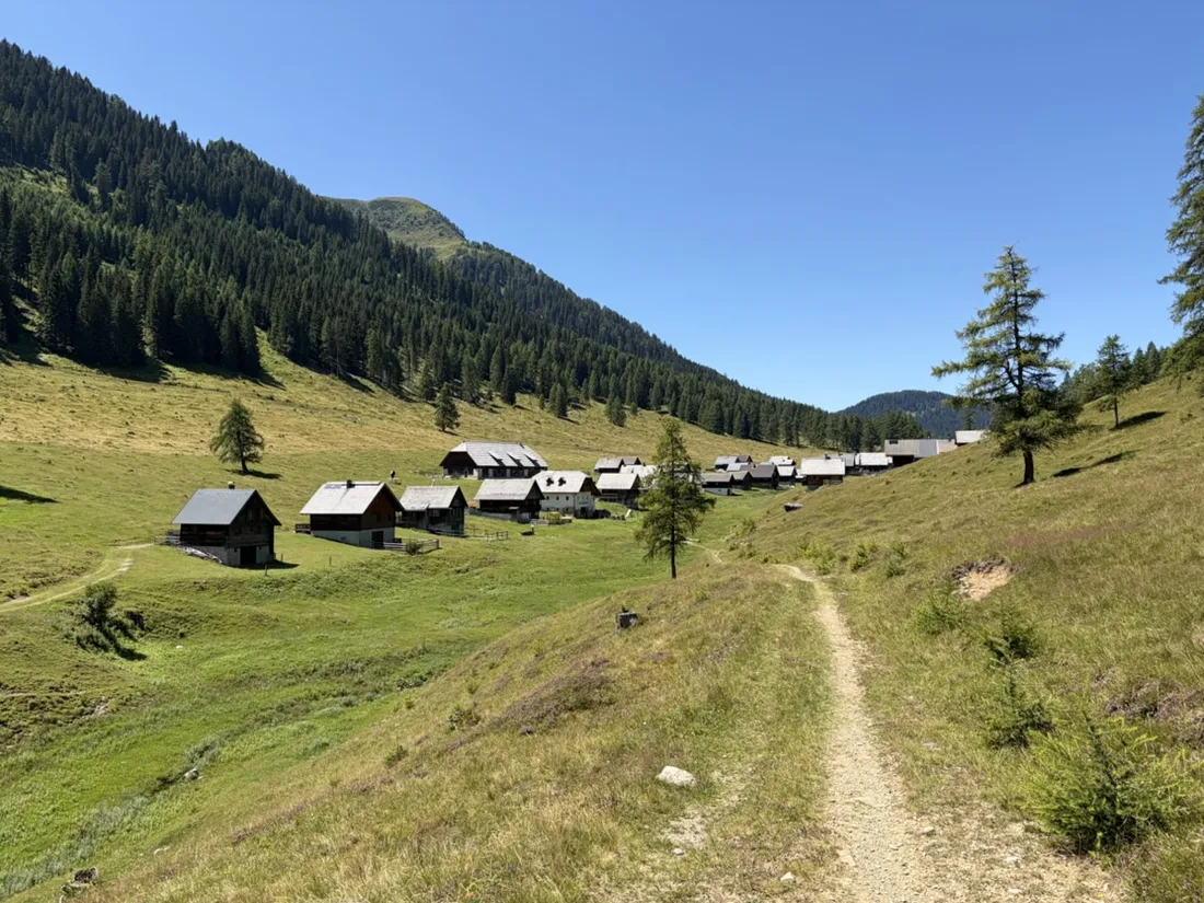 Die Dellacher Alm — ein Almdorf traditioneller Holzhütten auf der Hochweide an der Nordseite der Karnischen Alpen, am Ende des Anstiegs erreicht