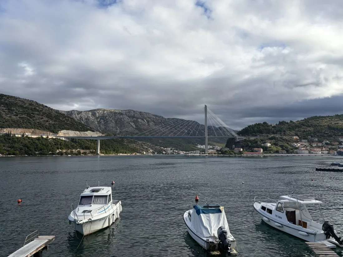 Small boats below the Franjo Tuđman Bridge, seen from the waterfront path at Solitudo