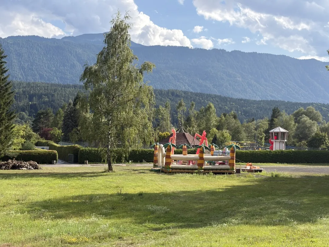 A lakeside bathing meadow beside the lake — in summer the Pressegger See warms to about 28 °C, one of the warmest swimming lakes in Austria